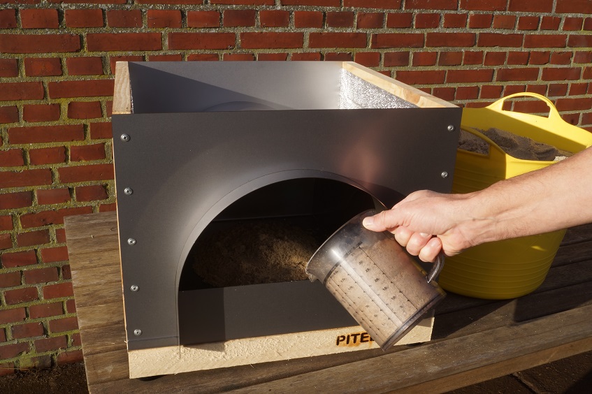 Filling the bottom of the garden oven with sand