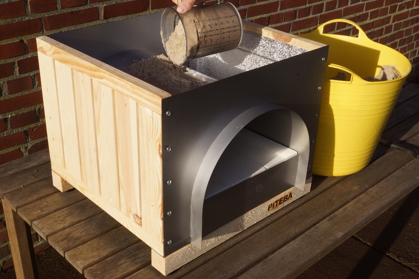 Filling the PITEBA outdoor oven with sand
