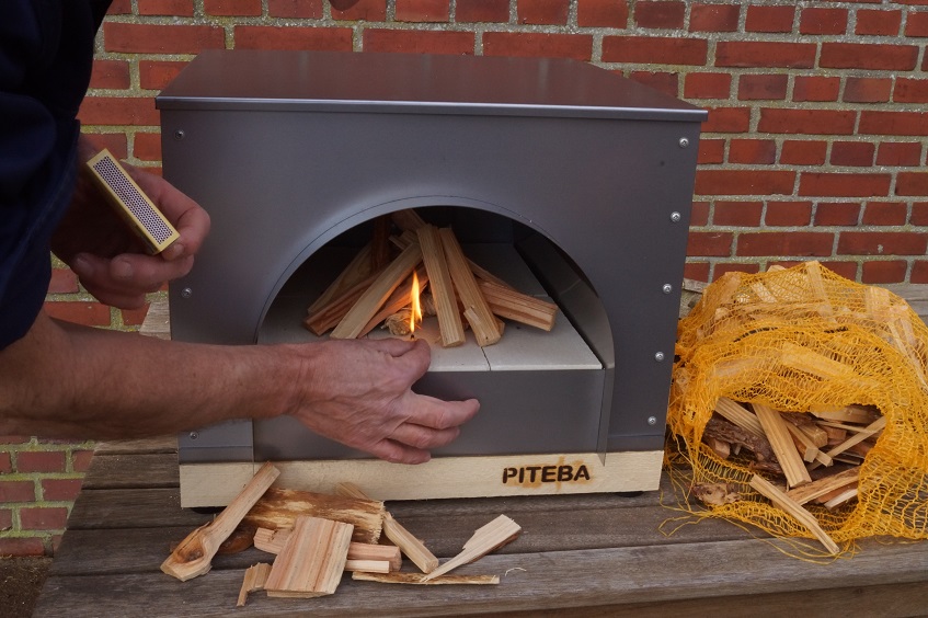 lighting the wood in the pizza oven 